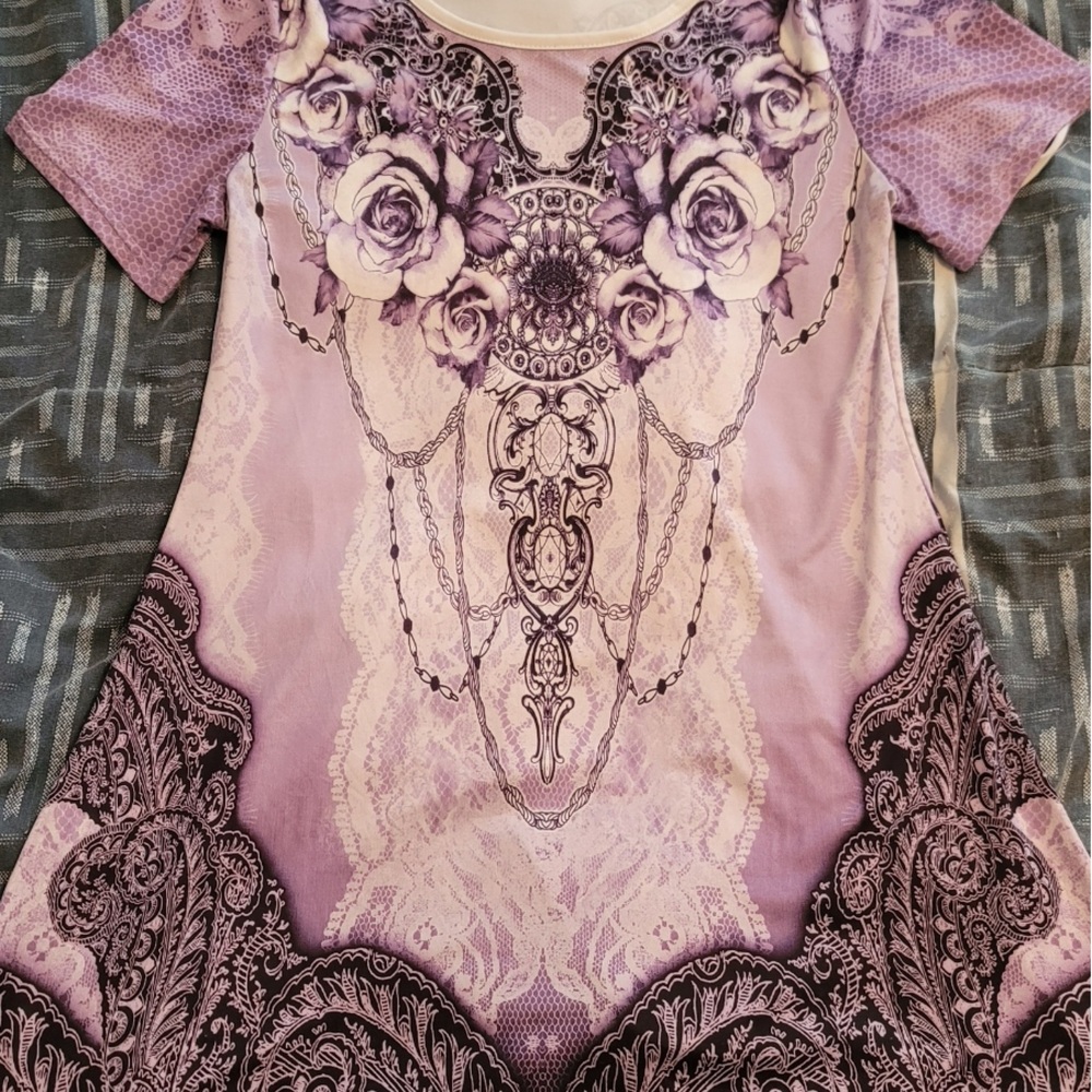 Short sleeve purple top with design. Material is loose fitting.
